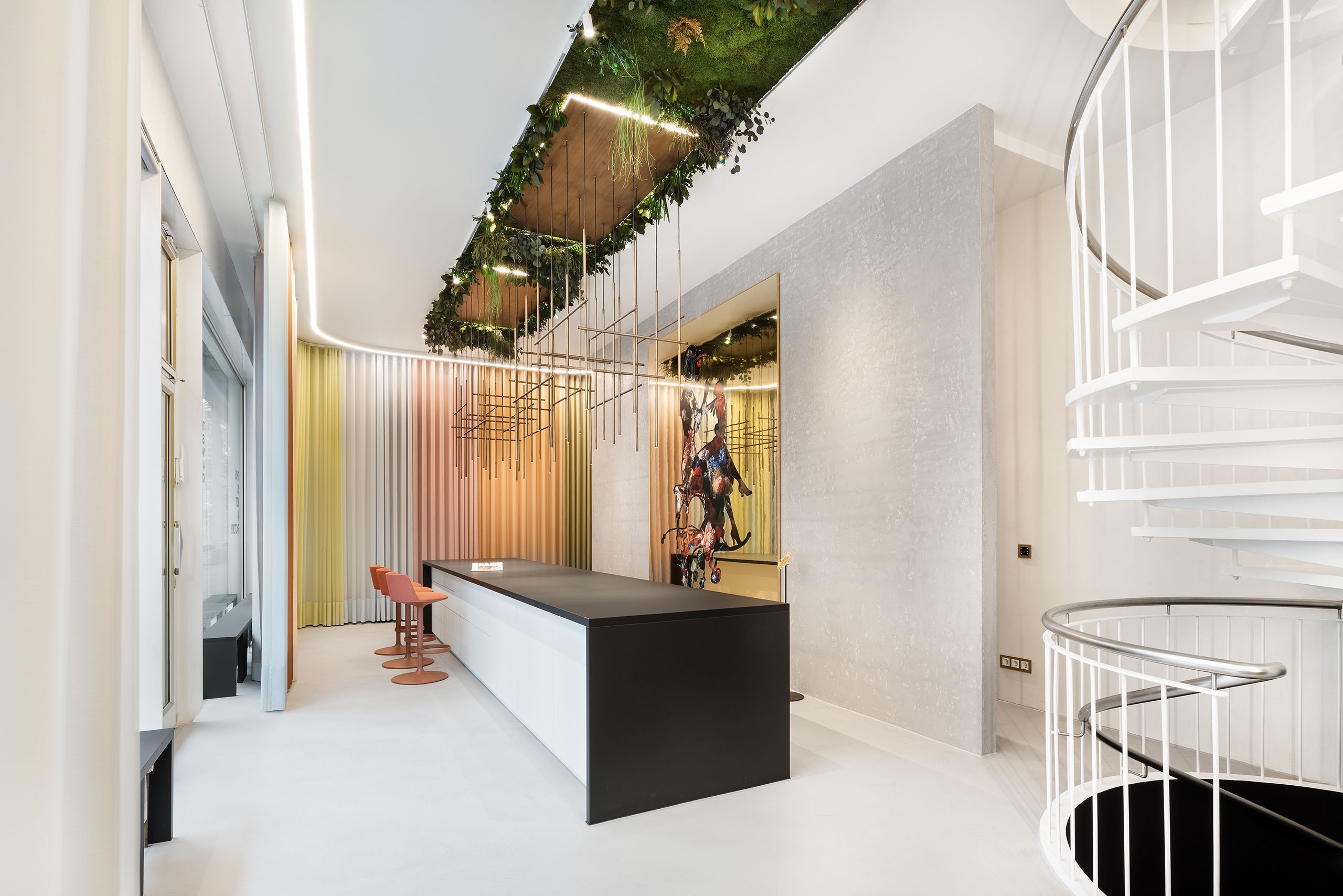 Showroom mit verschiedenfarbigen Vorhängen von Création Baumann. Eine Wendeltreppe verbindet die Stockwerke.