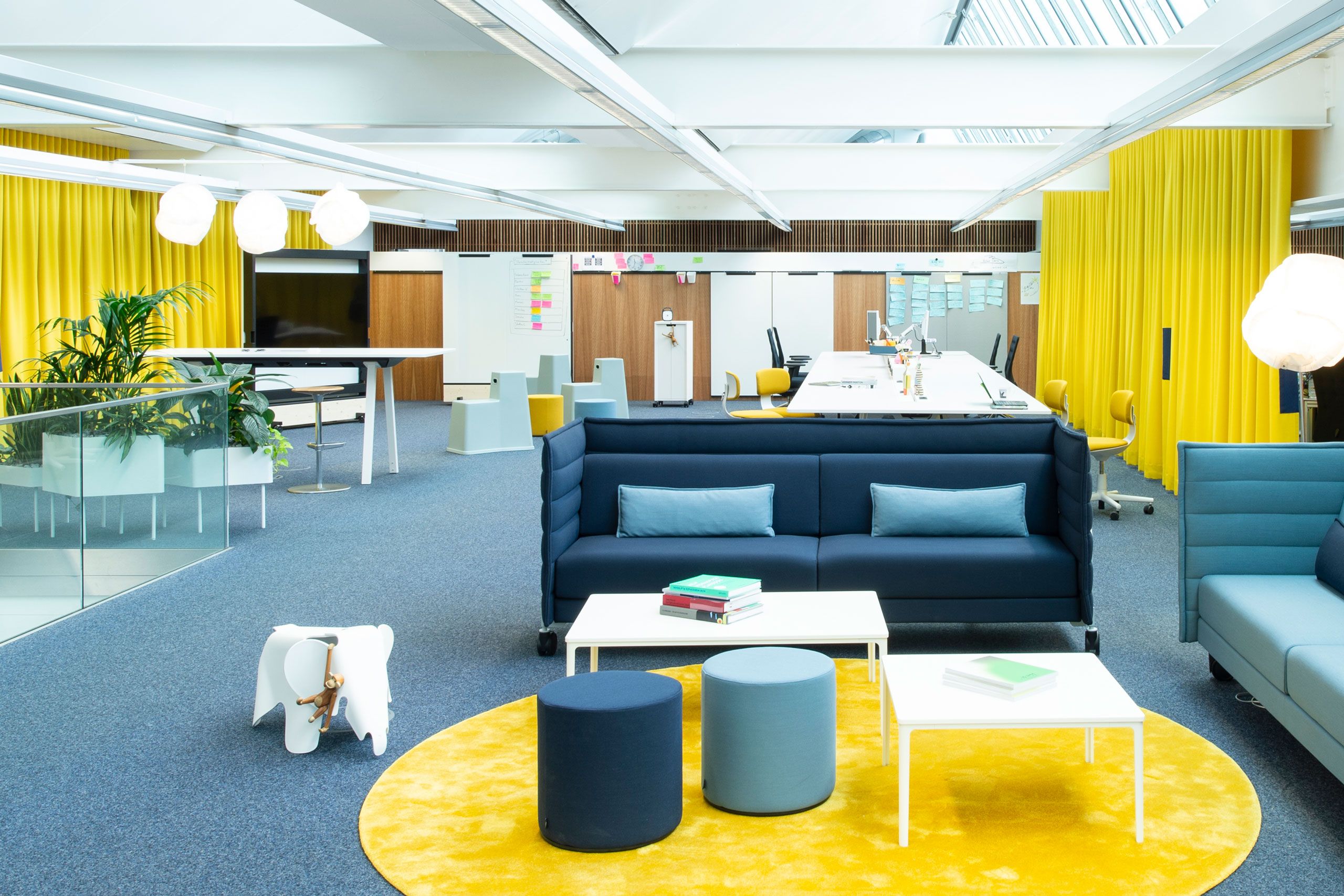 Modern office interior design with yellow LORD curtains from Création Baumann for acoustic optimization and room separation.