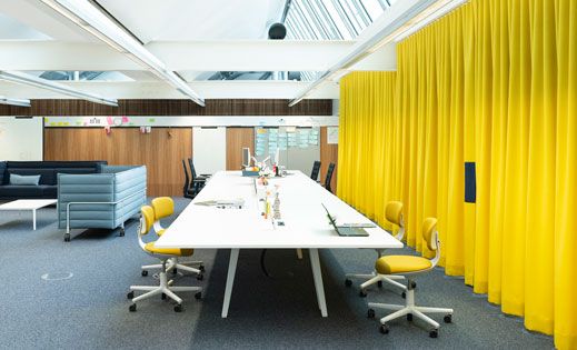 Moderne Büroeinrichtung mit gelben LORD Vorhängen von Création Baumann für Akustikoptimierung und Raumtrennung.