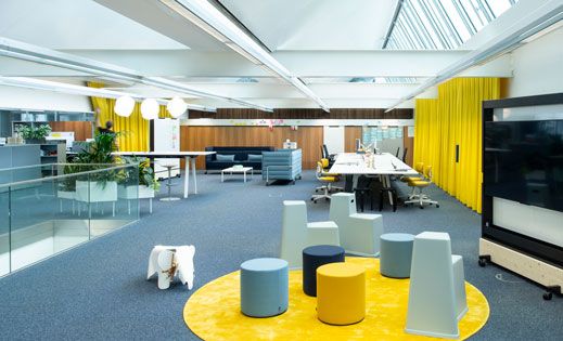 Moderne Büroeinrichtung mit gelben Vorhängen von Création Baumann für Akustikoptimierung und flexible Raumzonierung.