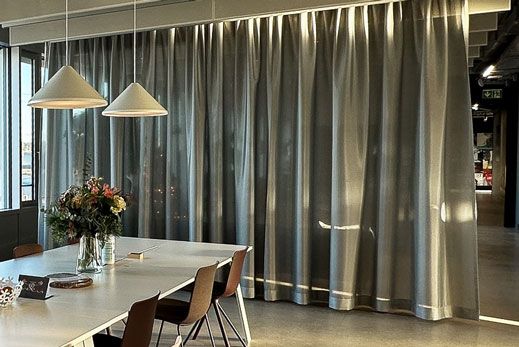 Curtain for spatial and acoustic separation of lounge area and meeting table.