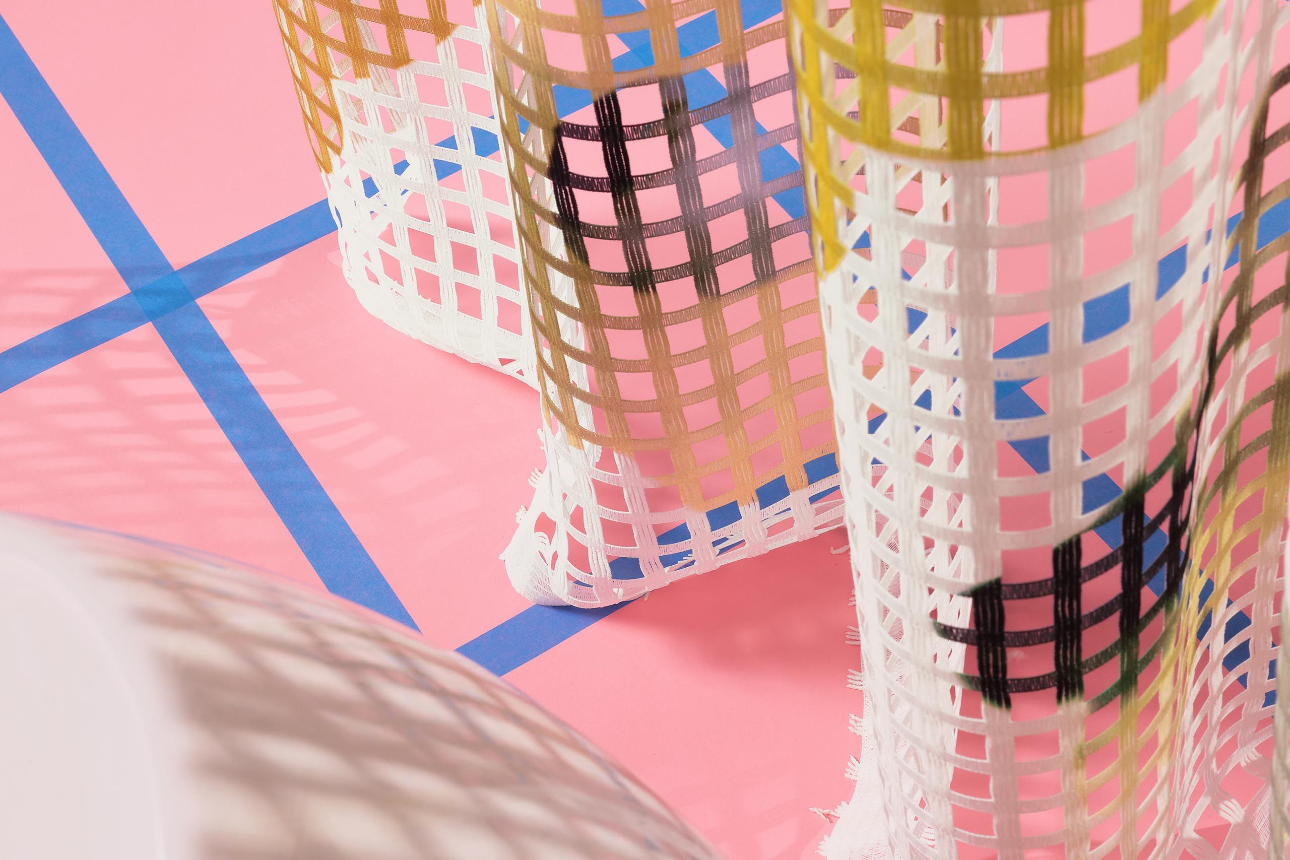 Transparenter Netz-Vorhangstoff von Création Baumann mit floralem Muster mit feiner Gitterstruktur, modern inszeniert in farbigem Design-Interior mit skulpturaler lila Vase und grafischem Boden.